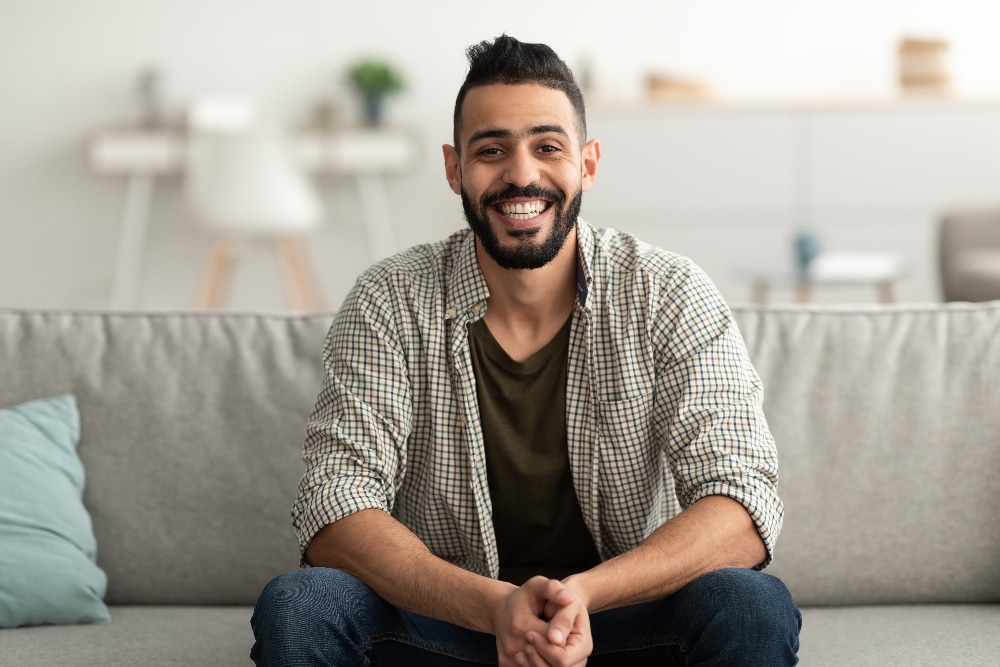 portrait of man sitting on couch smiling